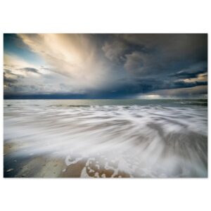 Contrastrijke landschapsfoto van het Banjaardstrand in Zeeland met een donkere wolkenlucht en stromend water op de voorgrond.